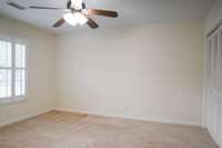 The back bedroom has both white shutters and double closets.