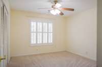 Front bedroom featuring a double closet and white shutters.