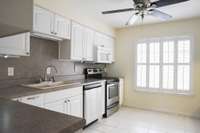 The kitchen boasts of both lots of cabinet and counter space, making it very functional. The windows overlook the private front courtyard, and the shutters add beauty and light. Stainless Steel appliances included.
