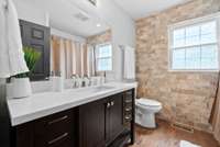 Full bathroom upstairs with a tub/shower combo with tile walls.