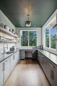 This working pantry boasts lots of natural light and includes a dedicated coffee bar, refrigerator, sink/disposal, double wall ovens, and ample amount of storage.