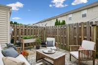 Private fenced patio with charming raised garden bed and plenty of space to relax or entertain—your personal outdoor escape!