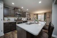 Granite countertops, walk-in pantry, stainless appliances, an enormous eat-at island and sleek dark cabinetry make this kitchen both functional and inviting.