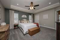 Down its own hallway is the primary bedroom, an oasis of cool and calm at the back of the house. Flooded with light from the dual windows is a beautiful accent wall and trey ceiling with can lights and ceiling fan, and the ensuite bath to the right.