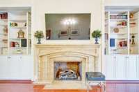 The hand-crafted, concrete fireplace is flanked by built-in shelving and cabinetry.