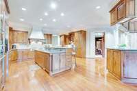 The main level kitchen features a gorgeous island, abundant custom cabinetry, and a bar that overlooks the billiard room.