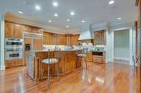 Features include: gas range with two grill tops, custom exhaust hood, double ovens, extra warming drawer, cabinet front refrigerator and two dishwashers.