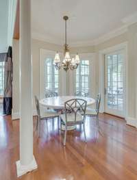 The breakfast area in this home is a delightful and welcoming space that encourages relaxation, conversation, and enjoyment of a delicious meal with family and friends. It opens to the back terrace.
