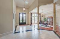 Sunlight pours into the 16-foot tall entry over the travertine and marble inlay flooring.