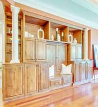 Tailored to occupy the southern wall, this cabinetry ensures that all available space is used efficiently.  Hidden billiards storage custom cabinets also offer seating space, and storage options.