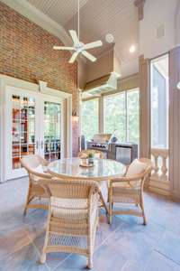 Dining area on the terrace with an outdoor kitchen/grill and overhead exhaust behind. No need to worry about the rain getting in the way of a cookout!