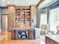 The executive office has beautiful wood custom shelving and a bay window to take in the natural light.