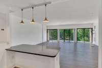 The eat-in kitchen flows into a large living space. A first glimpse of the green trees and woods...so serene!