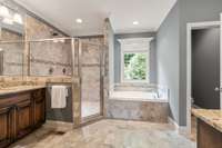 Primary bathroom with large tile shower and dual shower head and separate tub.