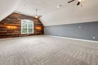 Accent wall in bonus room with shelves and lighting.