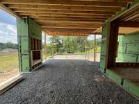 Rear Covered Porch with wood-burning fireplace *this house is under construction. Photo taken 6/22/25
