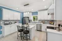 So much quartz counter space, island and cabinets for storage