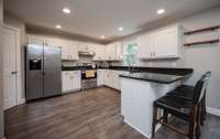 The kitchen sports all stainless steel appliances and lovely granite. And the best part? That door to the left leads to a walk-in pantry!!