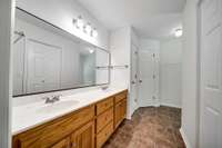 The master bath boasts a standalone shower and soaking tub, a spacious vanity, and a brand-new oversized glass mirror.