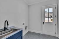 Utility room with washer and dryer hook-ups. Poplar Plan - Photos depict builders' quality, this model will differ.