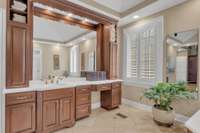Lovely cabinetry offers plenty of storage along with a seated vanity space.