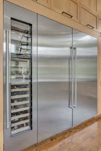 Sub-Zero refrigerator, freezer and 60 bottle wine chiller are seamlessly integrated into custom cabinetry—pairing luxury performance with sleek, modern design.