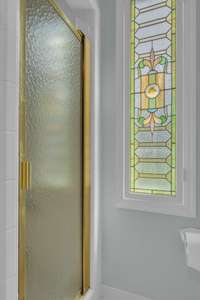 A pretty stained glass window gives this space charm and a touch of whimsy.