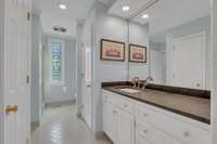 Note the large vanity space provided in the attached suite. This bathroom has neutral paint and floor tiles and plenty of storage.