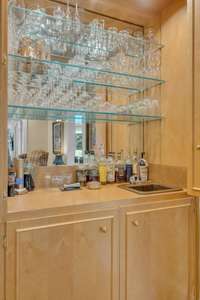 This space features a sink and mirrored shelving—designed for effortless entertaining and elegant storage.