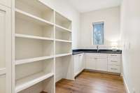 large walk in pantry with custom built ins & sink