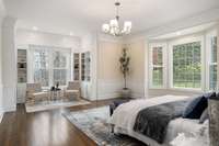 Large primary bedroom with custom built-ins and sitting area! Expansive moldings and gorgeous windows that offer plenty of natural lighting!