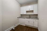Laundry with custom cabinetry and Quartzite countertops