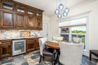 Wine fridge, Natural Stone Backsplash, Upper Cabinets have Seed Glass Doors. Counter is natural Quartzite.