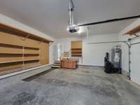 Two car garage with lots of shelving and a sink!