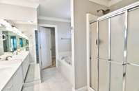 The primary bath with double vanities and a separate shower and tub.