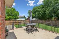 Raised brick deck in fenced backyard