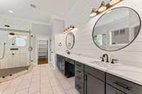 The double-sink vanity area is spacious, featuring numerous drawers and elegant countertops.