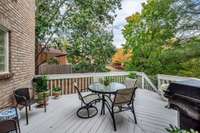 The large deck off the living room is enveloped by mature trees, making it a serene spot for relaxing.