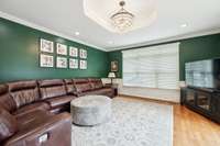 Living room with high end light fixture and french doors leading to a private patio