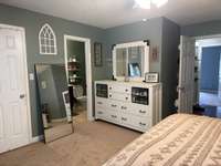 another view of primary bedroom with full bath new carpet & walk in closet