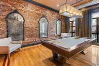 The exposed brick walls and antique mirrors help brighten and warm the industrial loft