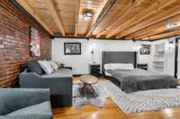 The Master Bedroom feels light and bright with fresh paint, while the exposed beams & brick keep things cozy