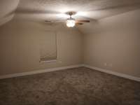 Spacious Bonus Room with Vaulted Ceiling and Ceiling Fan.