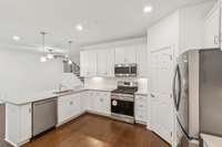 Gas stove, tile backsplash, large refrigerator, walk in pantry. Tons of cabinet space and drawers.