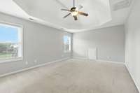 Primary bedroom with lots of natural light and double tray ceilings.