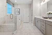 Gorgeous private bathroom in your Primary suite featuring frameless tiled walk-in shower, soaking tub, ceramic tile flooring and quartz countertops.