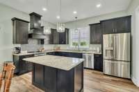 Great kitchen with island, hood and stainless appliances