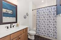 This full bath is located downstairs complete with tile surround, tile flooring and quartz counter tops.