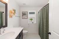 This upstairs bath with tile surround tub/shower and tile flooring is convenient to the upstairs secondary bedrooms.