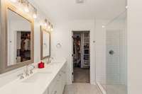 This luxurious space boasts a dual sinks with modern finishes